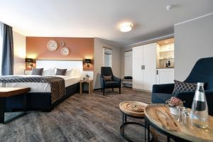 ein Hotelzimmer mit einem Bett und einem Wohnzimmer in der Unterkunft Christinenhof & Spa - Wellnesshotel am Rande des Spreewalds in Tauer