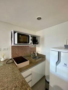 a kitchen with a sink and a microwave at Um sonho à beira mar in João Pessoa