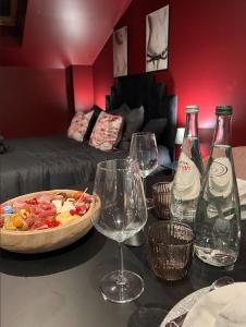a table with wine glasses and a pizza on it at PARENTHESE LOVE - Amour & Tentation Suite Balnéo SPA Proche Orly-Paris in La Ville-du-Bois