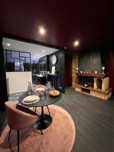 a living room with a table and chairs and a fireplace at PARENTHESE LOVE - Amour & Tentation Suite Balnéo SPA Proche Orly-Paris in La Ville-du-Bois
