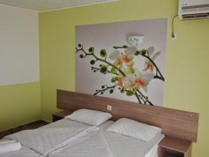 a bedroom with a bed with a flower mural on the wall at Morska Zvezda Guest House in Chernomorets