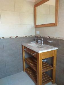 a bathroom with a sink and a mirror at Reina de las Cortaderas in Merlo