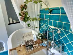 a bathroom with a sink with a book and flowers at jasmine cottage in Luni +132 photos