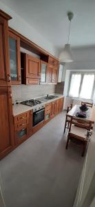 uma grande cozinha com armários de madeira e uma mesa em Casa Al Lago em Bolsena