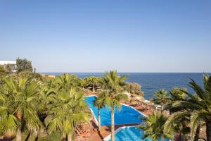 an aerial view of a resort with palm trees and the ocean at Europa Resort Hotel in Panormos Rethymno