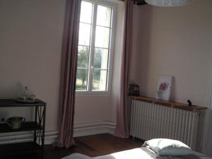 a bedroom with a bed and a window and a radiator at Aux vieux fours in Noaillac