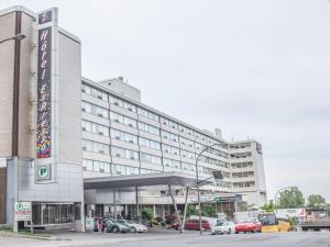 een groot gebouw met auto's geparkeerd op een parkeerplaats bij Hotel Espresso Montreal Centre-Ville / Downtown in Montreal