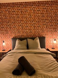 a bedroom with a large bed with a brick wall at BEAU T3 STYLE INDUSTRIEL N20 ORLY PARIS WIFI Underground Industry in La Ville-du-Bois