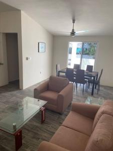 Sala de estar con 2 sofás y mesa en Casa de verano totalmente equipada y amueblada, en Santa Cruz Huatulco
