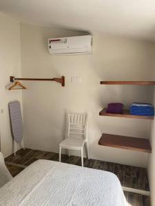 1 dormitorio con cama, silla y calentador en Casa de verano totalmente equipada y amueblada, en Santa Cruz Huatulco