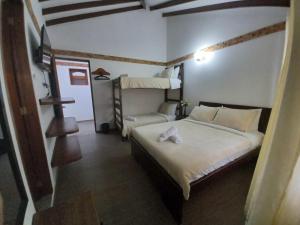 een slaapkamer met een bed en een stapelbed bij Casa Lewana in Villa de Leyva