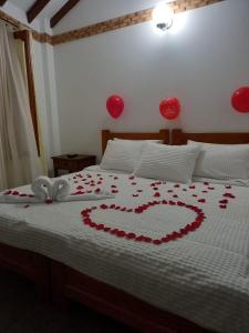 Una cama con un corazón hecho de rosas rojas en Casa Lewana, en Villa de Leyva