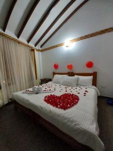 Un dormitorio con una cama con rosas rojas. en Casa Lewana, en Villa de Leyva
