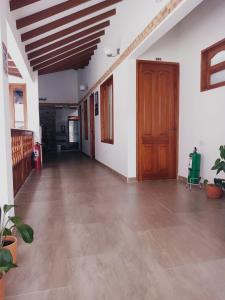 an empty hallway with a wooden door and plants at Casa Lewana in Villa de Leyva