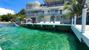 a house with a swimming pool next to the water at Down South 118 Beach Resort in Oslob