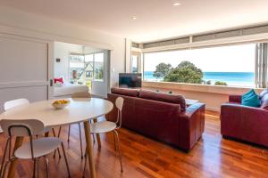a living room with a couch and a table at The Sands - Apartment 26 - Stay Waiheke in Onetangi