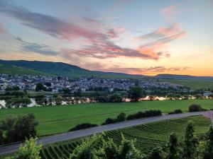 una strada attraverso le colline al tramonto con una città di Ferienhaus Elisa a Trittenheim