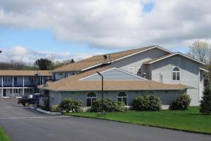 una casa blanca con techo marrón en Days Inn by Wyndham Middletown/Newport Area, en Middletown