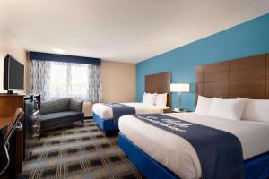 a hotel room with two beds and a television at Days Inn by Wyndham Middletown/Newport Area in Middletown
