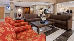 a living room with two couches and a coffee table at Best Western Plus Ambassador Suites in Venice