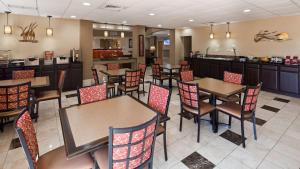 a restaurant with tables and chairs and a bar at Best Western Plus Ambassador Suites in Venice