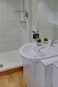 a white bathroom with a sink and a shower at BEST WESTERN The Crianlarich Hotel in Crianlarich