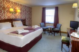pokój hotelowy z łóżkiem i telewizorem w obiekcie BEST WESTERN The Crianlarich Hotel w mieście Crianlarich