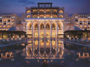 a large building with a pool in front of it at Shangri-La Qaryat Al Beri, Abu Dhabi in Abu Dhabi
