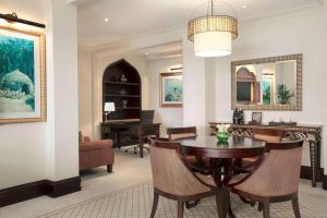 a living room with a table and chairs and a piano at Shangri-La Qaryat Al Beri, Abu Dhabi in Abu Dhabi