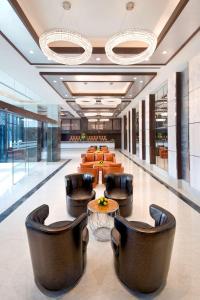 a lobby of a hotel with leather chairs and tables at Radisson Blu Gorakhpur in Gorakhpur