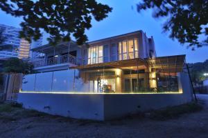 a house with a balcony on top of it at Smell rose beach garden in Batu Ferringhi