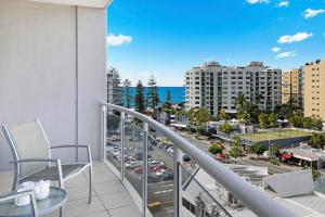 a balcony with a view of a city at Pandanus Mooloolaba in Mooloolaba