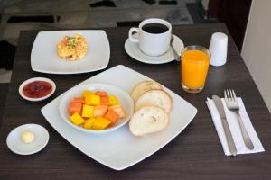 a table with a plate of breakfast food and a cup of coffee at Ayenda Victoria Comfort in Bucaramanga