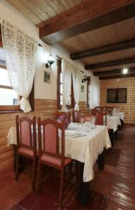 a dining room with tables and chairs with white table cloth at Adriana Guesthouse in Jezerce