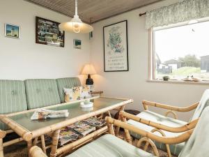 - un salon avec un canapé, une table et des chaises dans l'établissement 4 person holiday home in L kken, à Løkken