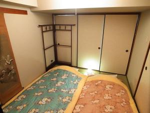 a small bedroom with a bed and some cupboards at Asayake in Tokyo