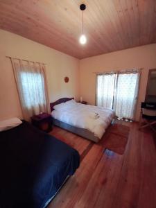 a bedroom with two beds and two windows at Hotel Nativo in Santiago