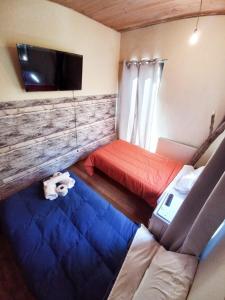 a small room with two beds and a flat screen tv at Hotel Nativo in Santiago