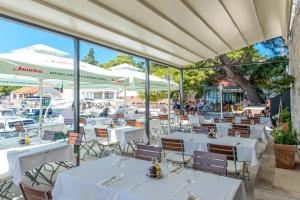 un ristorante con tavoli e sedie bianchi e finestre di AVA Studio apartment and Room a Dubrovnik