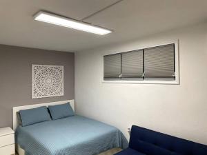 California Apartments في يابوكوا: غرفة نوم بسرير ازرق ونافذة