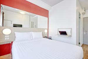 1 dormitorio con 1 cama blanca grande y espejo en Red Planet Pattaya SHA Extra Plus, en Pattaya central