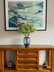 a wooden dresser with a vase on top of it at Sunseeker Motor Inn in Batemans Bay