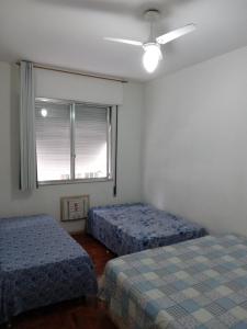 1 dormitorio con 2 camas y ventana en Copacabana uma quadra da praia, en Río de Janeiro