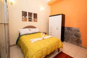 una camera con un letto con una coperta gialla di Apartment in the Plaza de Armas Cusco a Cuzco
