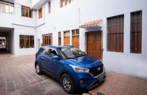 a blue car parked in front of a building at Apartment in the Plaza de Armas Cusco in Cusco