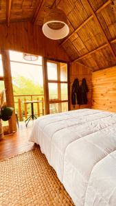 ein Schlafzimmer mit einem weißen Bett in einem Zimmer mit Fenstern in der Unterkunft Tropical House in La Vega