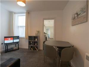 a living room with a table and a television at Lower Ashby Apartments in Scunthorpe