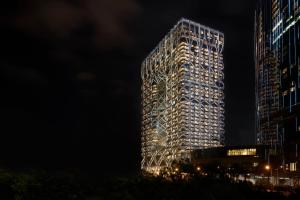 a tall building with lights on it at night at City of Dreams - Morpheus in Macau