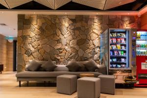 a living room with a couch in front of a stone wall at City Inn Macau in Macau