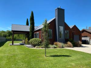 ein Haus mit einem kleinen Baum im Vorgarten in der Unterkunft 4 Tarndale Place in Hanmer Springs